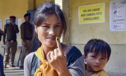 A voter shows her finger marked with indelible ink after