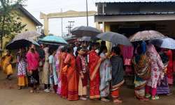 Voters wait in a queue at a polling station to cast their