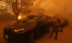 A woman cries as the Palisades Fire advances in the Pacific Palisades neighborhood of Los Angeles