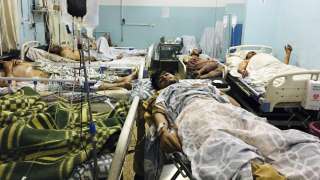 Wounded Afghans lie on a bed at a hospital after a deadly