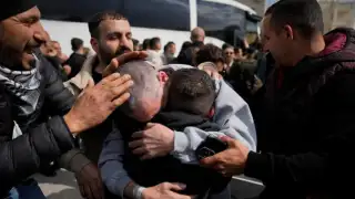 Palestinian prisoners are greeted as they exit a Red Cross