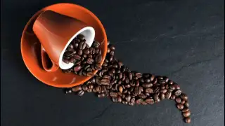 coffee beans on orange ceramic mug