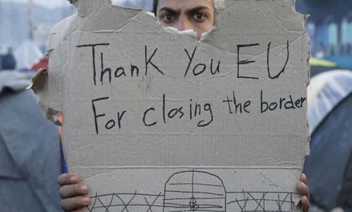 A refguee holds message, “Thank you EU for closing the