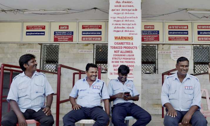 Guards sitting near the ticket counter of a closed cinema