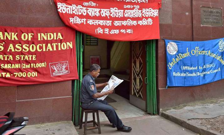 A security guard reads a newspaper in front of a closed