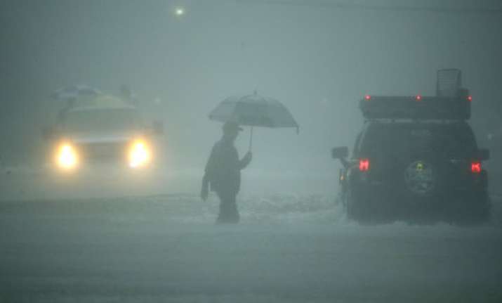 A man walks in heavy rain in Houston, Texas on Aug 27