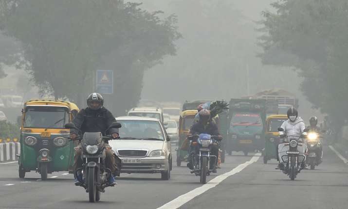 People commute during the foggy in New Delhi on Saturday.