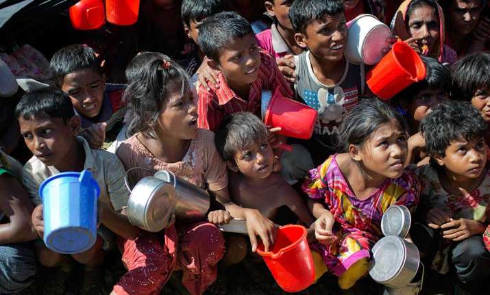 Rohingya Muslim children wait to receive food handouts at