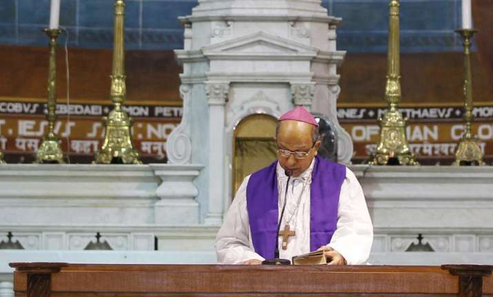 Archbishop of Delhi, Anil Couto, reads from a holy book