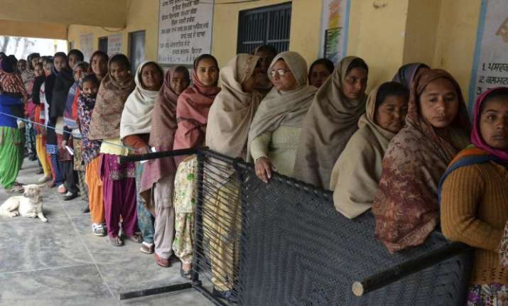 Voters standing in a queue at a polling booth to cast their