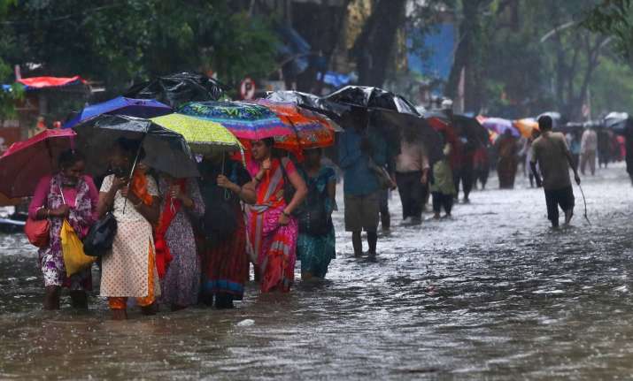 Pedestrians wade through a waterlogged street during