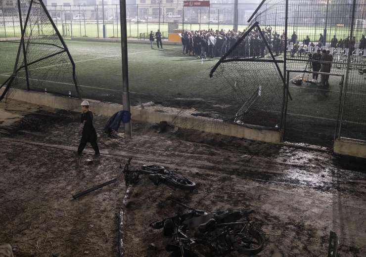 निवासी और अधिकारी एक फुटबॉल मैदान पर खड़े हैं, जहां रॉकेट से हमला किया गया, जिसमें कई बच्चे मारे गए - इंडिया टीवी