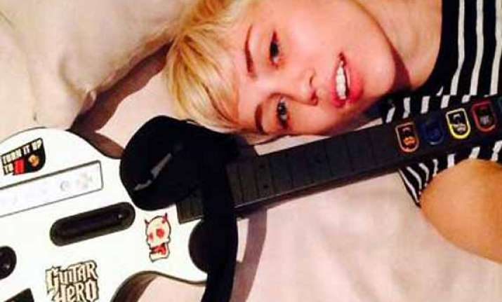 miley cyrus loves computer game guitar hero