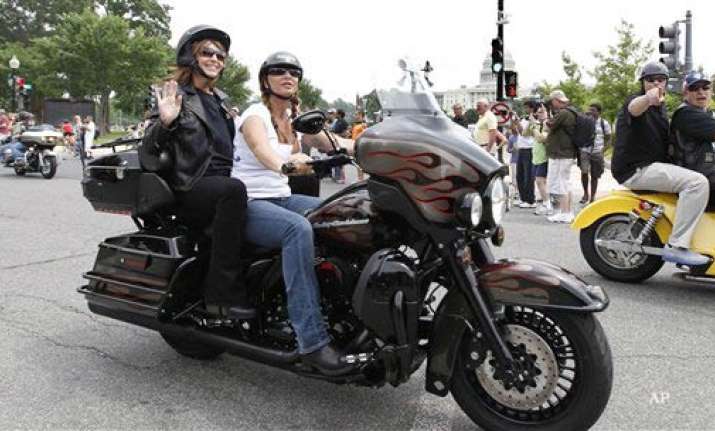sarah palin sits on back of a motorbike