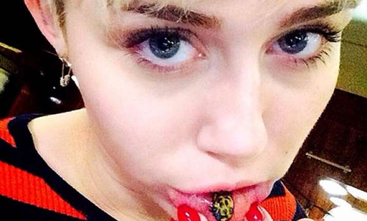 miley cyrus goes funky dons a tattoo on lower lip see pics