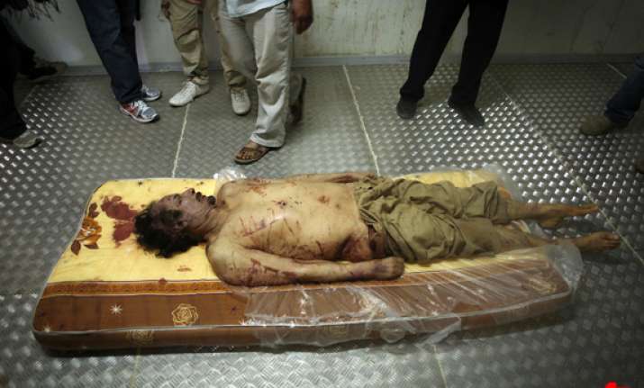 libyan official says gadaffi buried at dawn at secret