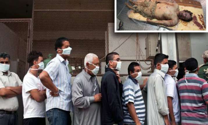 hundreds queue up to watch gaddafi son s bodies in meat