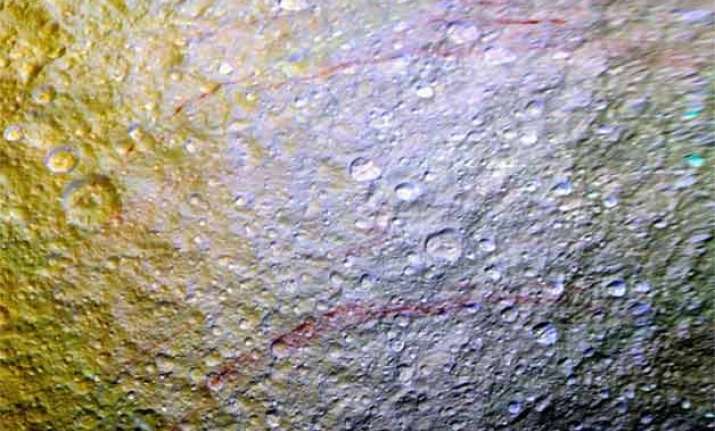 nasa probe spots unusual red arcs on icy saturn moon