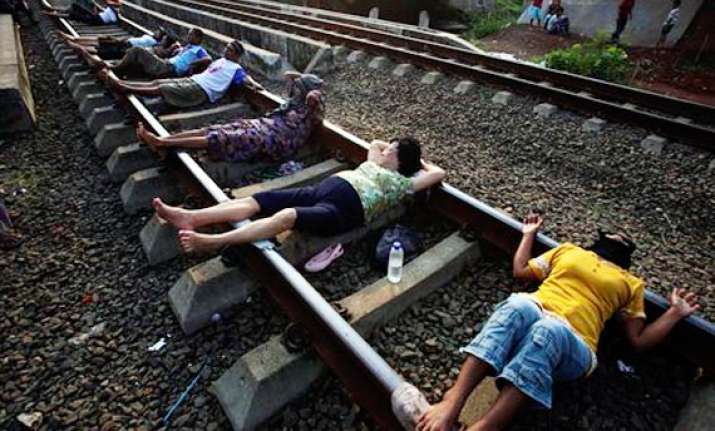 indonesians lie on rail tracks for electric therapy