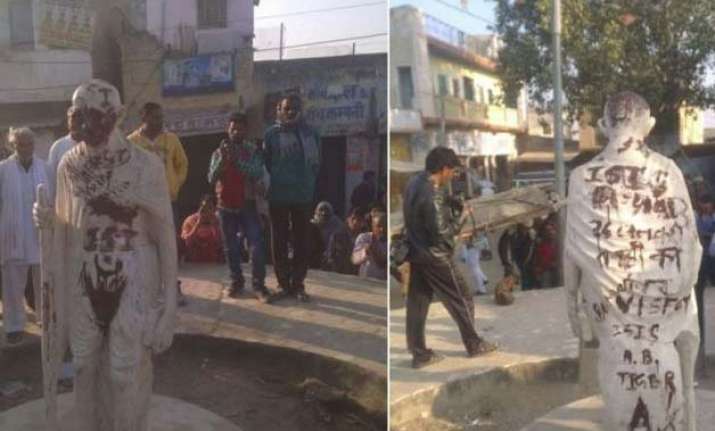 mahatma gandhi statue defaced with pro isis slogans in