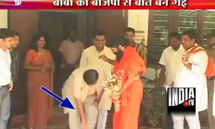 gadkari touches ramdev s feet seeks his blessings