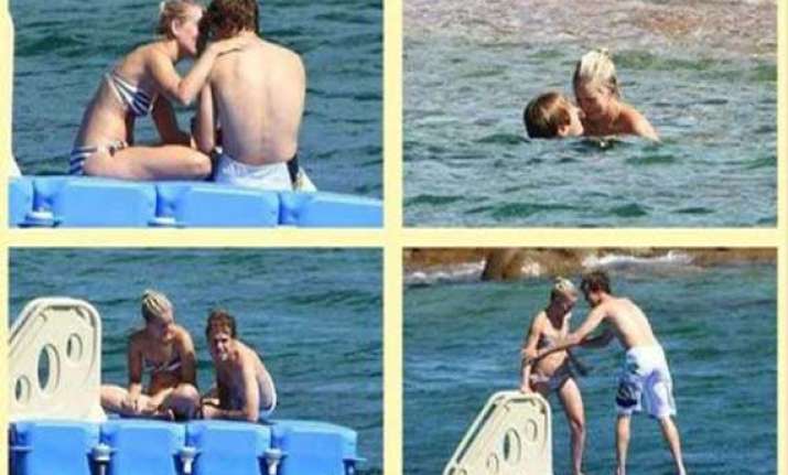 f1 racer vettel gets cozy with his girlfriend at a beach