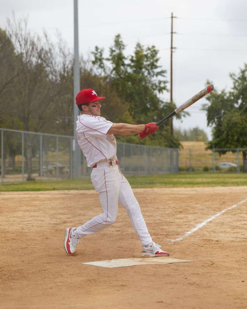 Nick was seen holding a baseball bat in a striking pose where he opted for a white co-ord with red stripes and a cap. He sported white sneakers. 