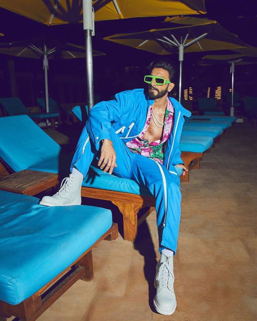 The dashing actor of Bollywood, Ranveer Singh is known for his bold fashion choices. The actor looked dapper in a neon blue jogger set. He paired his look with a printed shirt and white sneakers. In addition, he accessorised his look with a pearl necklace and green framed sunnies.