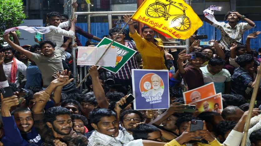 People standing on the roadside during the roadshow wave to the trio as they pass through the road in Vijayawada