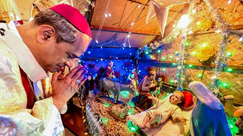 On Christmas, Archbishop Elias Joseph Gonsalves offers prayers at St. Francis de Sales Cathedral in Nagpur. The cathedral is filled with reverence as the Archbishop leads the congregation in celebrating the birth of Christ.