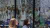 Two women walk past a Real Madrid poster of the team