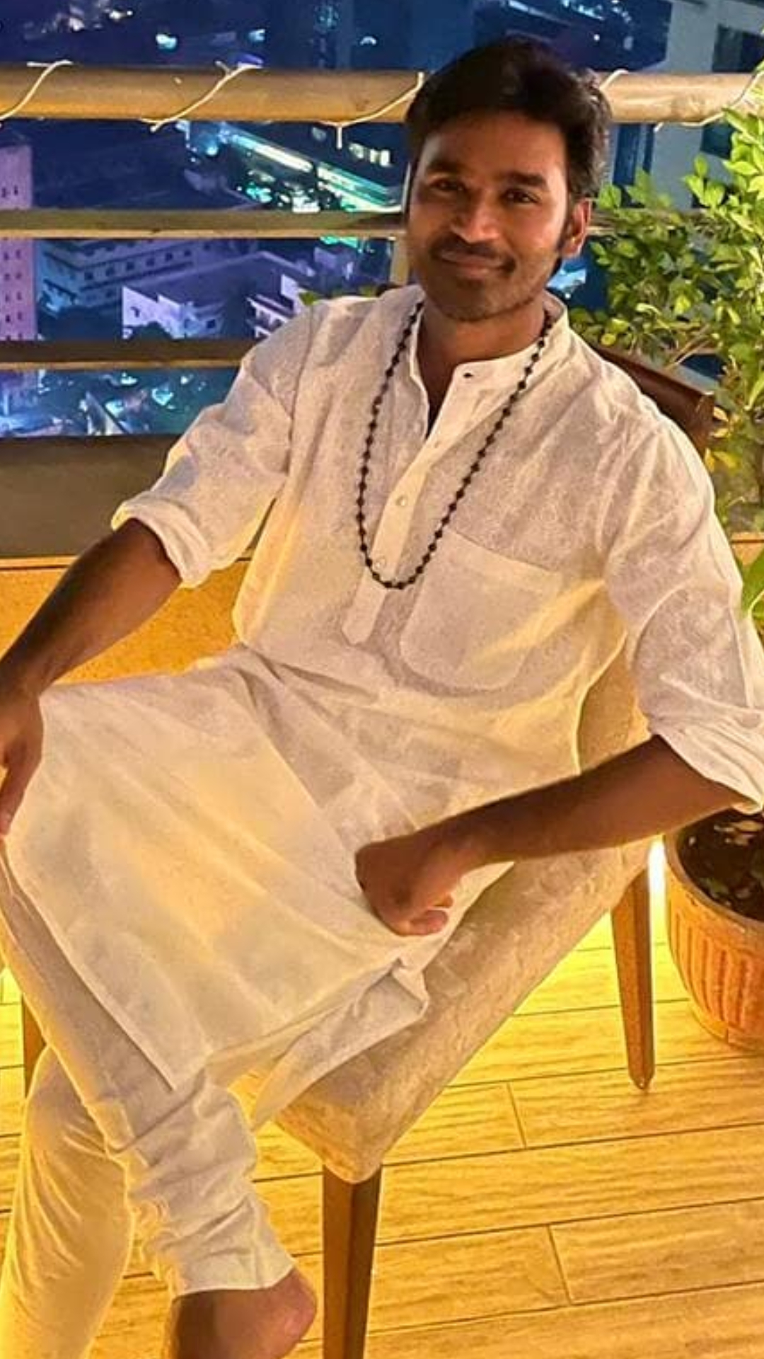 Dhanush looks all cool in a white kurta-pyjama set as he strikes a pose.