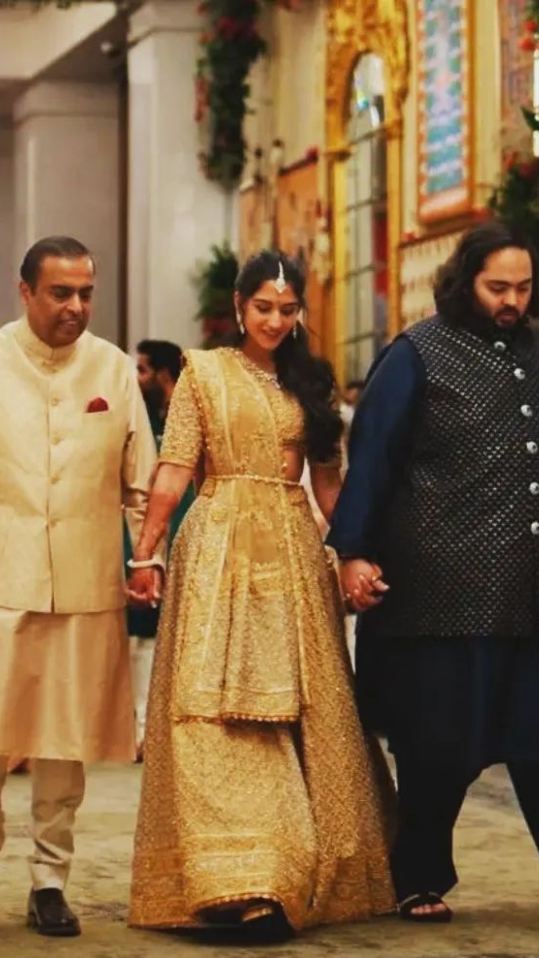 The happy couple, Anant Ambani and Radhika Merchant, walked hand-in-hand with Mukesh Ambani as they arrived for the engagement ceremony.