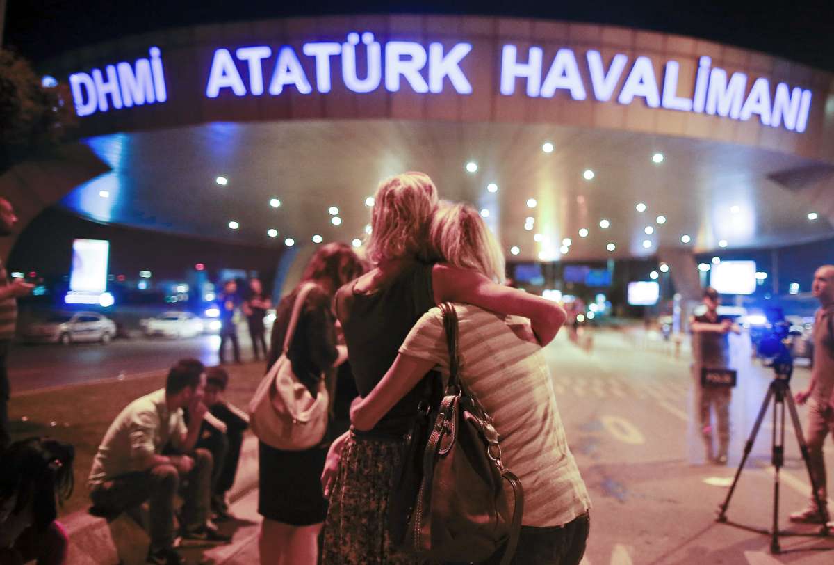 Passengers embrace each other at Istanbul's Ataturk airport after deadly attack