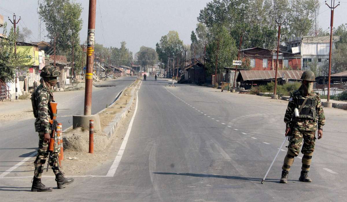 Security Personnel stand guard on a deserted street in Srinagar