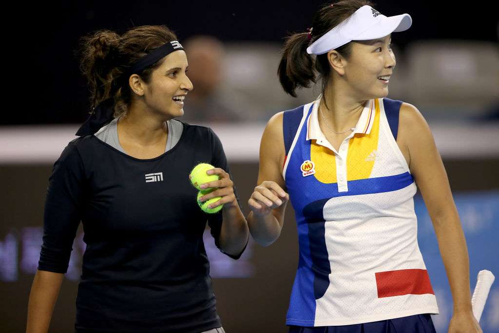 Sania Mirza of India and Shuai Peng of China react after winning a point during their Women's double quarterfinal match at China Open