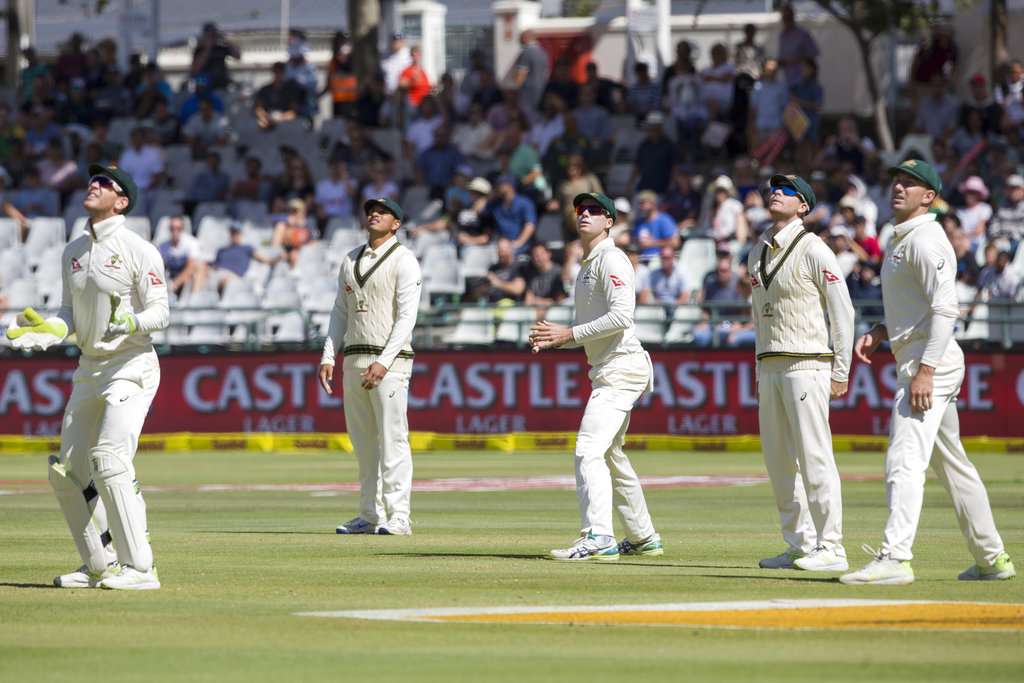 Australian team members watch as the ball flies for six on the fourth day of the third Test between South Africa and Australia at Newlands Stadium