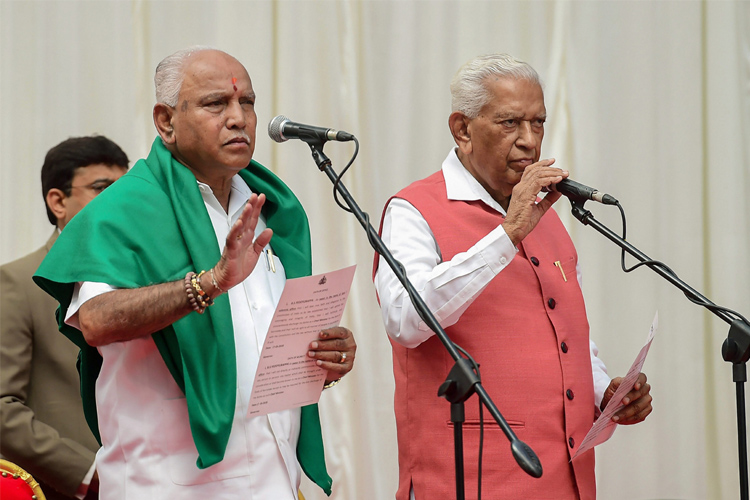 Karnataka Governor Vajubhai Vala administers oath to BJP leader B. S. Yeddyurappa as Chief Minister of the state at a ceremony in Bengaluru on Thursday. Karnataka Governor Vajubhai Vala administers oath to BJP leader B. S. Yeddyurappa as Chief Minister of the state at a ceremony in Bengaluru on Thursday.