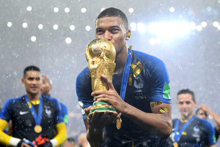 France's Kylian Mbappe poses with the World Cup trophy.
