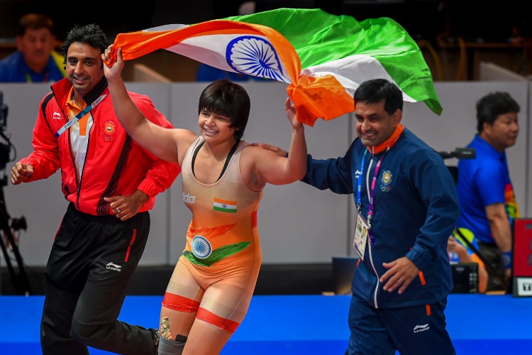 Divya Kakran celebrates after securing a bronze medal in a wrestling event.