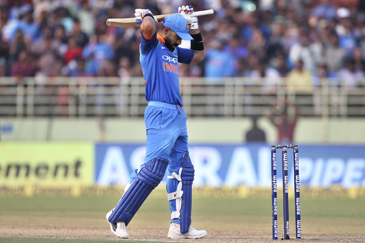 Virat Kohli celebrates scoring 10,000 runs in one-day internationals during the second one-day international cricket match between India and West Indies in Visakhapatnam.