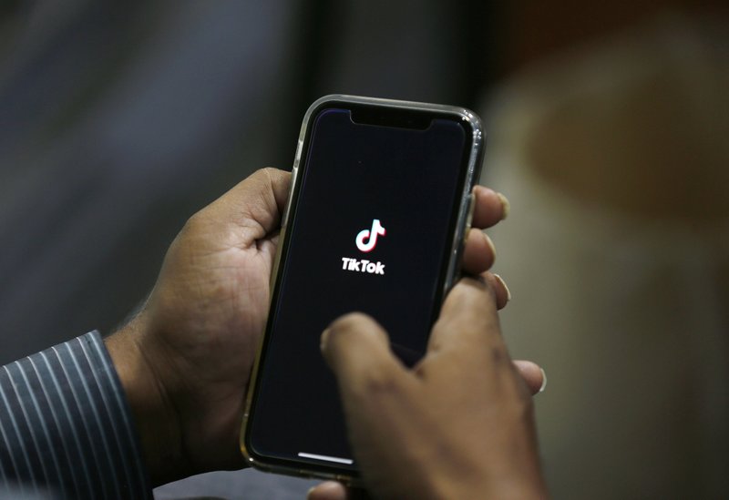 FILE - In this July 21, 2020 file photo, a man opens social media app 'TikTok' on his cell phone, in Islamabad, Pakistan. President Donald Trump said Saturday, Sept. 19, 2020 he&rsquo;s given his &ldquo;blessing&rdquo; to a proposed deal between Oracle and Walmart for the U.S. operations of TikTok, the Chinese-owned app he&rsquo;s targeted for national security and data privacy concerns. (AP Photo/Anjum Naveed, File)