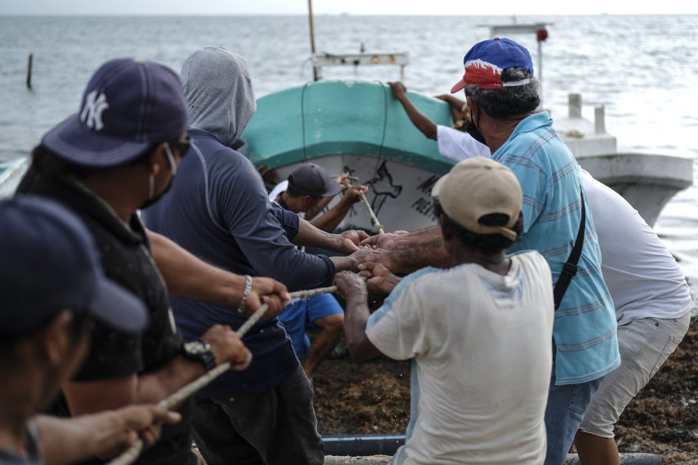 Fishermen pull in a boat before the arrival of Hurricane Delta in Puerto Juarez, Cancun, Mexico, Tuesday, Oct. 6, 2020. Hurricane Delta rapidly intensified into a potentially catastrophic Category 4 hurricane Tuesday on a course to hammer southeastern Mexico and then continue on to the U.S. Gulf coast this week. (AP Photo/Victor Ruiz Garcia)