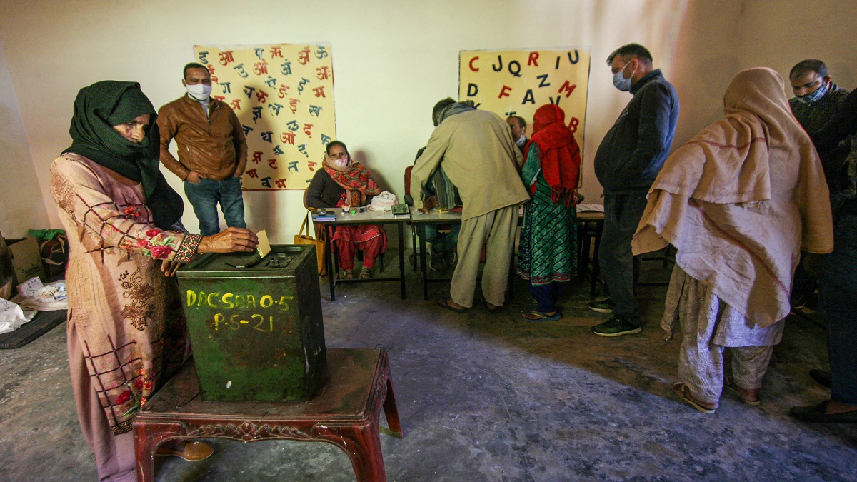 A woman casts her vote for the District Development Council elections, at Purmandal in Samba district