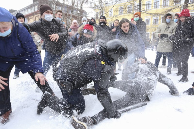 A policeman detains a man while protesters try to help him, during a protest against the jailing of opposition leader Alexei Navalny in St. Petersburg, Russia.