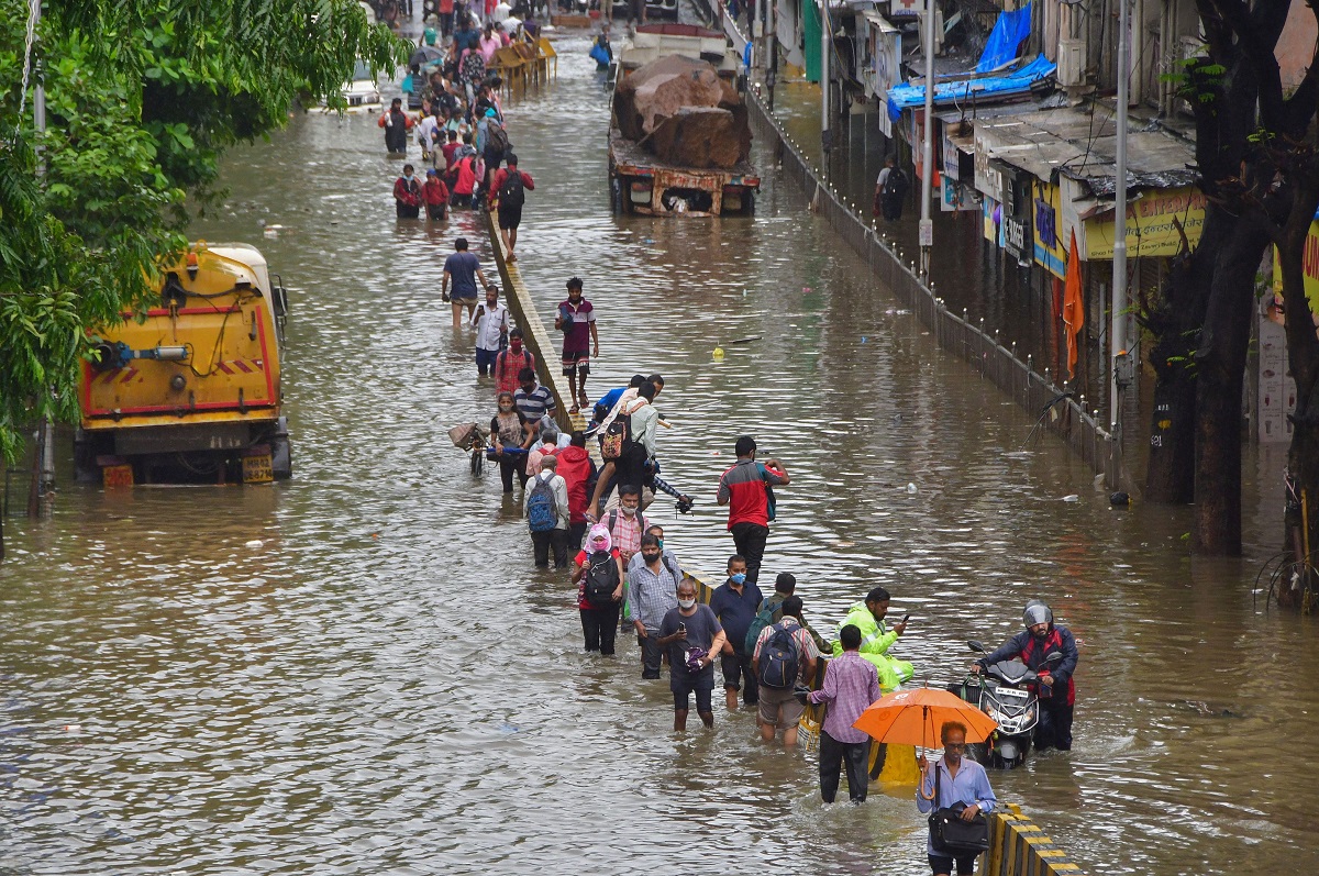 Mumbai: Commuters wade through a waterlogged street after heavy rain at Dadar in Mumbai
