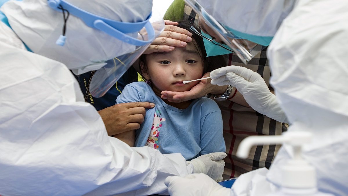 FILE | A child reacts to a throat swab during mass testing for COVID-19 in Wuhan in central China's Hubei province Tuesday, Aug. 3, 2021.&nbsp;