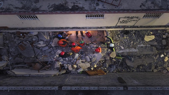 Mexican firefighters known as "Topos" work in the early morning hours in a search and rescue mission, amid the rubble from last week's 7.2 magnitude earthquake, in Les Cayes, Haiti.