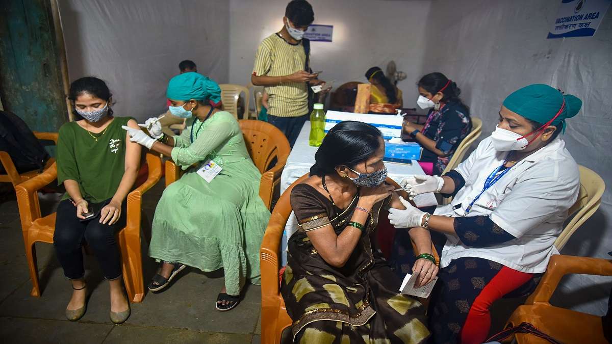 Health workers administer COVID-19 vaccine dose to beneficiaries during a vaccination drive for tribal people at Aarey Colony in Mumbai.