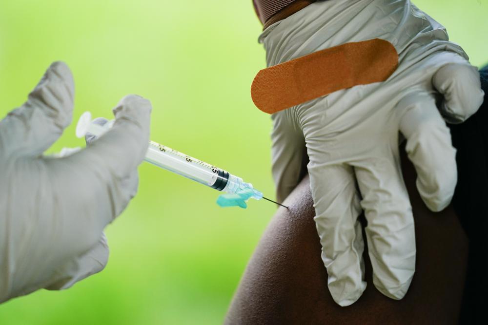 A health worker administers a dose of a Pfizer COVID-19 vaccine during a vaccination clinic at the Reading Area Community College in Reading
